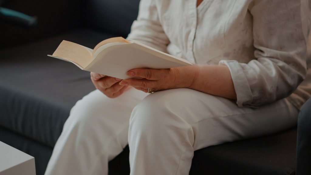 Grandmother reading novel story book in living room
